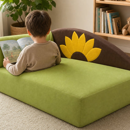 Kind liest auf dem Kindersofa Sonnenblume