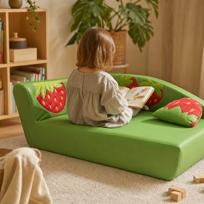 Kind liest auf dem Kindersofa Erdbeere